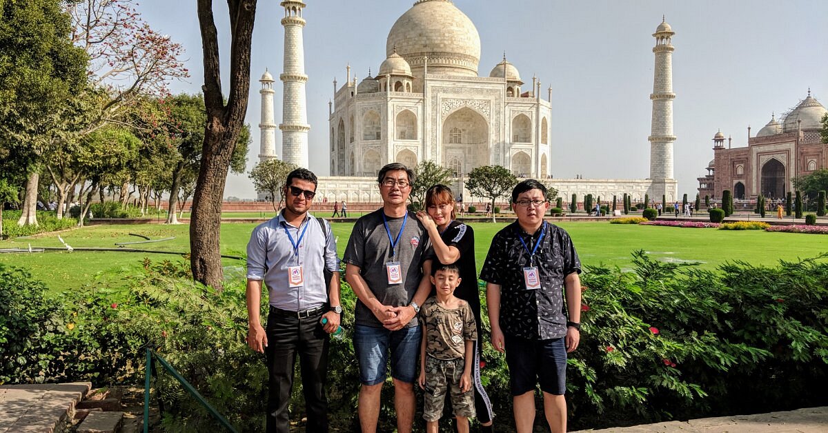 A family of four with their guide on the lawns of the Taj Mahal, Agra