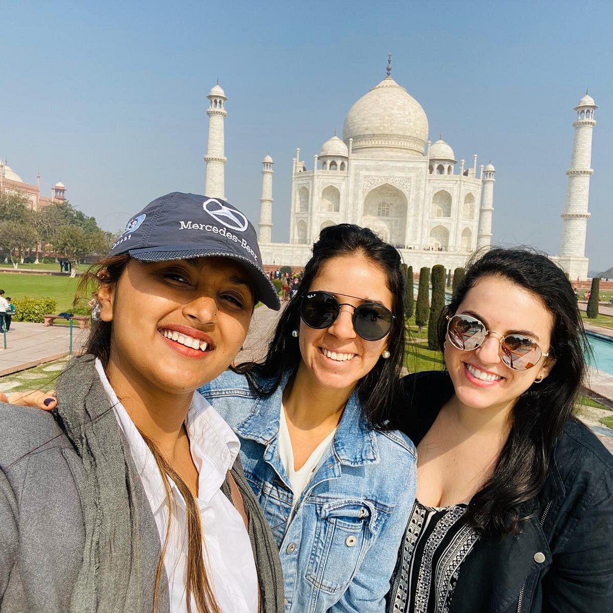Three friends photographed together with the Taj Mahal behind them